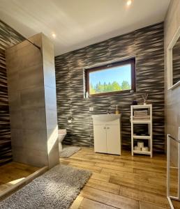 a bathroom with a sink and a toilet and a window at Domo Vila in Druskininkai