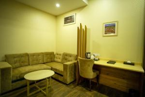 a living room with a couch and a table at Hotel Krinoscco in Ayodhya