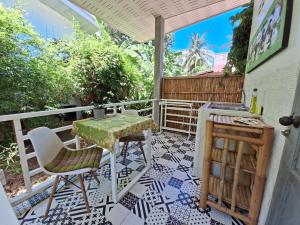 a patio with a table and chairs on a balcony at DG House in Thong Sala