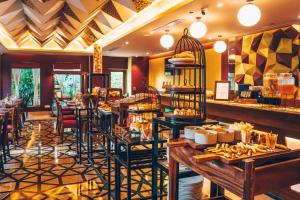 a restaurant with tables and chairs and a bar at Regenta Orkos Kolkata by Royal Orchid Hotels Limited in Kolkata