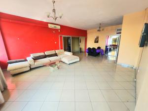 a living room with a couch and a red wall at Mimos Hotel in Tete