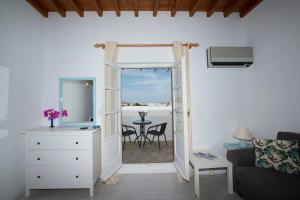 a living room with a door leading to a patio at Ibiscus down town location Myconos in Megali Ammos