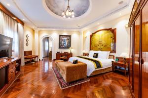 a bedroom with a large bed and a television at Hotel Majestic Saigon in Ho Chi Minh City