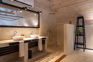 a bathroom with two sinks and a large mirror at Jambiani Villas in Jambiani +62 photos