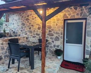 a patio with a table and chairs and a stone wall at SRC Bella Casa in Ohrid +7 photos