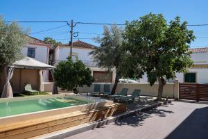 a swimming pool in a yard with chairs and trees at Casa Alvega - 50m do Rio - Piscina com Hidromassagem in Alvega