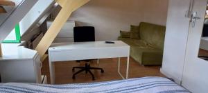 a small room with a white desk and a couch at Aangenaam & redelijk geprijsd in Amersfoort