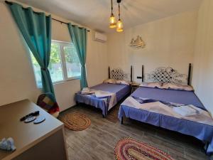 a bedroom with two beds and a window at Porto Lima in Limanu