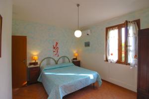 a bedroom with a blue bed and a window at Podere Cerretini in Montepulciano