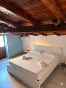 a large white bed in a room with wooden ceilings at Casa Van Gogh Catania in Catania