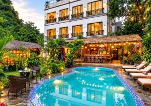 a hotel with a swimming pool in front of a building at Catba Backpackers - Sea Vibe Pool Bar & Bungalow in Cat Ba