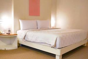 a bed with white sheets and pillows in a room at Das House in Kolhapur