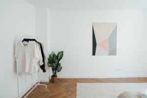 a white room with a plant and a mirror at The Haus HANS Nuremberg in Nuremberg +81 photos