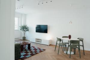 a white living room with a table and chairs at The Haus HANS Nuremberg in Nuremberg