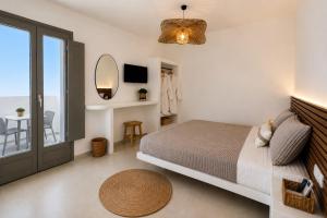 a bedroom with a bed and a mirror and a table at Danа̃e Sun&Sea Stays in Livadi