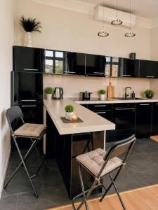 a kitchen with black cabinets and a island with chairs at Otium Old Town Boutique in Krakow