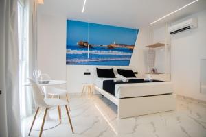 a white bedroom with a bed and a table at Apartamentos Alsa in Conil de la Frontera