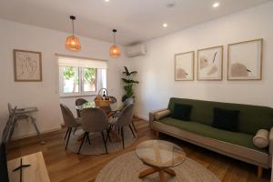 a living room with a green couch and a table at Casa Alvega - 50m do Rio - Piscina com Hidromassagem in Alvega