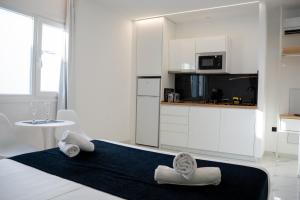 a white room with a bed with towels on it at Apartamentos Alsa in Conil de la Frontera +167 photos
