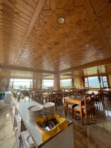 a restaurant with wooden ceilings and tables and chairs at Landmark Diamond Hill in Panaoti