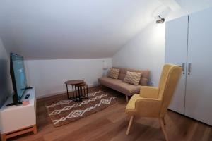 a living room with a couch and a chair at Casa Alvega - 50m do Rio - Piscina com Hidromassagem in Alvega