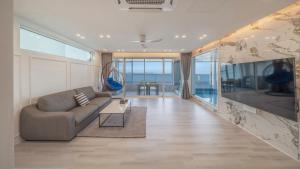 a living room with a couch and a view of the ocean at Pohang Etoile Poolvilla in Pohang