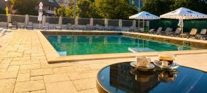 a swimming pool with a table and drinks on it at Atrium Hotel in Vulcan