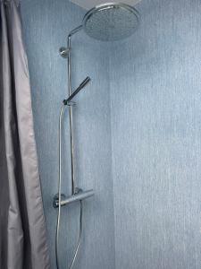 a shower in a bathroom with a blue wall at The Hidden Sea View in Sønderborg +27 photos