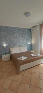 a bedroom with a large bed with two lamps at Roccazzo 16 in Cefalù