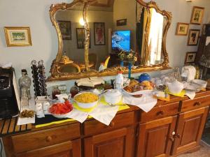 ein Buffet mit Schüsseln voller Speisen und einem Spiegel in der Unterkunft Degas in Vicopisano