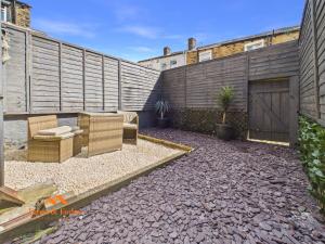 a patio with two chairs and a fence at Cosy Colne Cottage in Colne