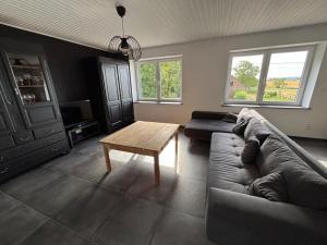 a living room with a couch and a coffee table at Le Gîte du Trieux - Berzée in Berzée