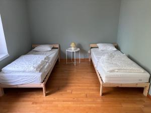two twin beds in a room with a table at Le Gîte du Trieux - Berzée in Berzée +13 photos