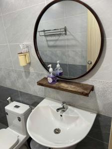 a bathroom with a sink and a mirror over a toilet at Lunar Stay HCM in Ho Chi Minh City +72 photos