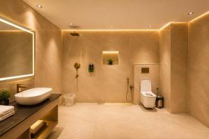 a bathroom with a sink and a toilet at The Aura Hotel & Resort in Noida +104 photos
