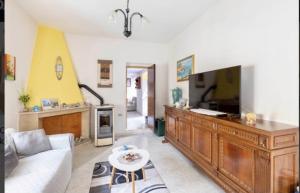 a living room with a couch and a tv at la casa rossa in Suni