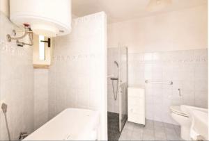 a white bathroom with a toilet and a sink at la casa rossa in Suni