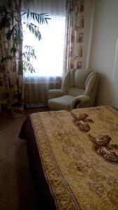 エカテリンブルクにあるApartment on Ispanskih Rabochih 35のベッドルーム1室(ベッド1台、椅子、窓付)