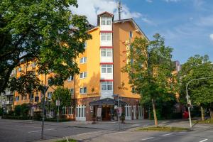 a large yellow building on a city street at Park Hotel Laim in Munich