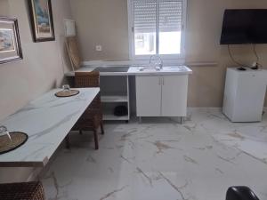 a kitchen with a marble floor and a sink at Casa Colón en la mancha in Herencia