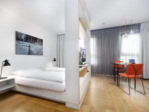 a bedroom with a bed and a desk and a table at smartments Wien Hauptbahnhof - Serviced Apartments in Vienna +21 photos
