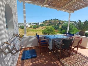 a patio with a table and chairs on a balcony at Meraki lipsi apartment in Leipsoi