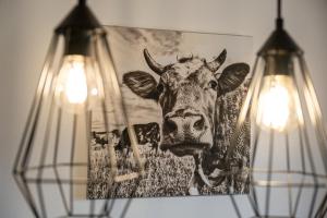 a picture of a cow hanging on a wall with lights at Chalet Ahornblick in Mühlen +13 photos