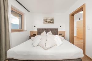 a bedroom with a white bed with white pillows at Chalet Ahornblick in Mühlen
