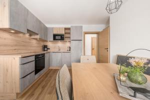 a kitchen and dining room with a wooden table and chairs at Chalet Ahornblick in Mühlen