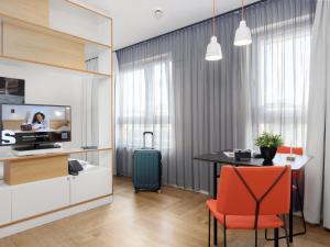 a kitchen and dining room with a table and a television at smartments Wien Hauptbahnhof - Serviced Apartments in Vienna