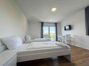 a white room with two beds and a window at AM102 moderne Monteurwohnung in Amberg