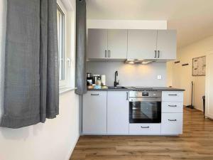 a kitchen with white cabinets and a stove at AM102 moderne Monteurwohnung in Amberg