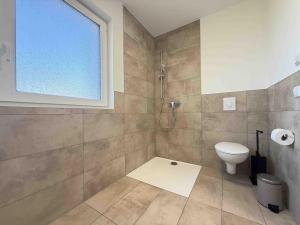 a bathroom with a shower and a toilet and a window at AM102 moderne Monteurwohnung in Amberg