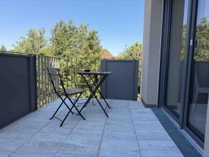 a patio with two chairs and a table on a balcony at AM102 moderne Monteurwohnung in Amberg